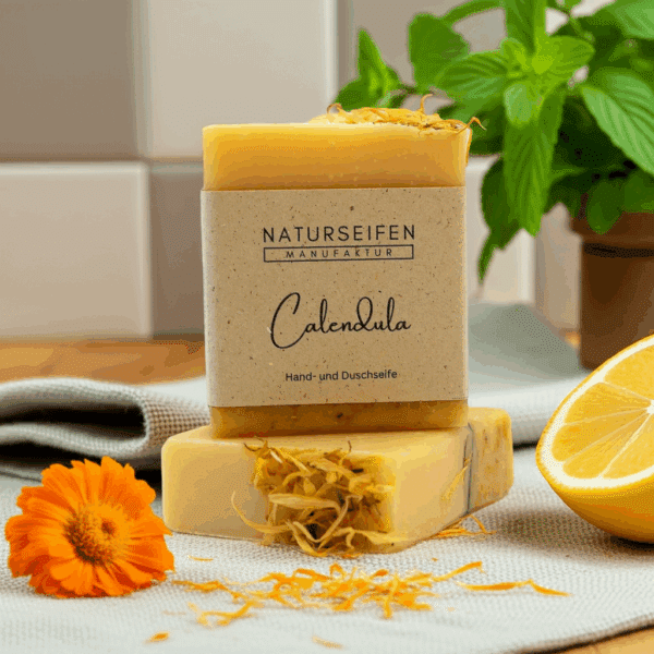 Seifenstück mit Ringelblumenblüten und einem Etikett mit der Aufschrift 'Calendula'.